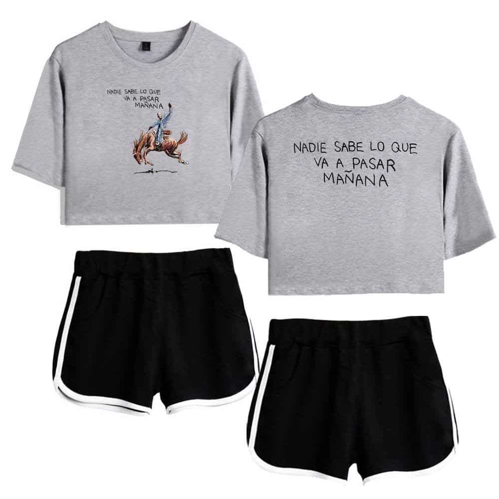Comfortable gray crop top with a humorous illustration of a person riding a horse and the phrase "Nadie sabe lo que va a pasar mañana" printed on it, paired with sporty black shorts with white trim.
