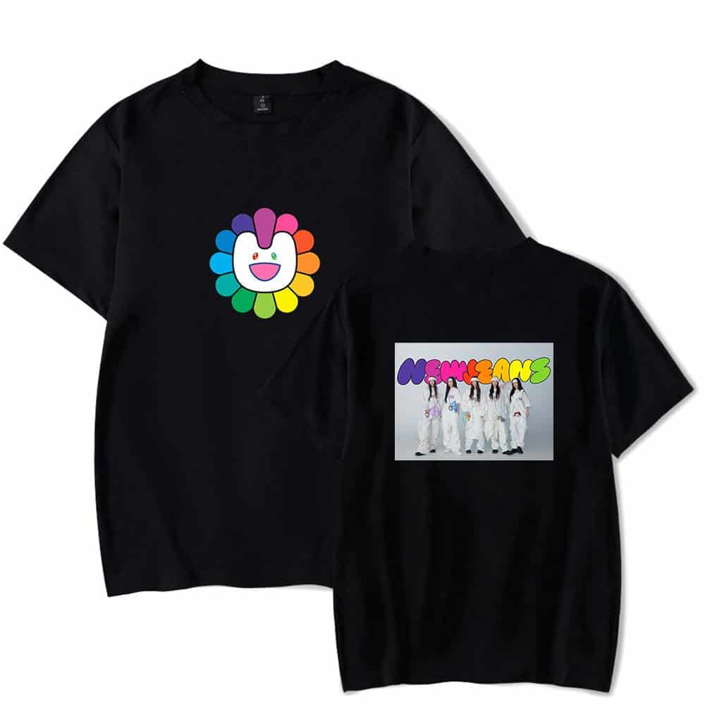 Happy flower character logo with rainbow petals on black t-shirt, colorful K-pop girl group NMIXX merchandise, vibrant streetwear fashion item, youthful and trendy apparel for fans and collectors.