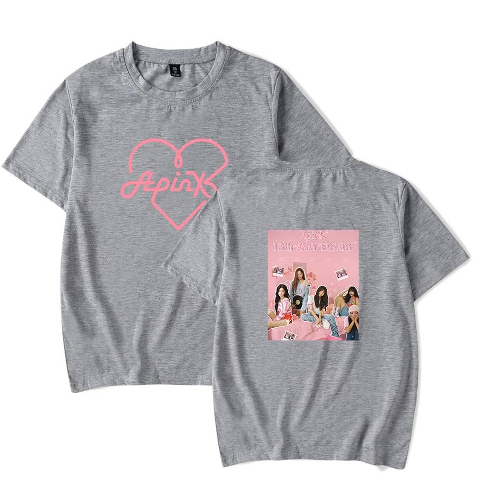 Apink 13th anniversary graphic T-shirt in grey with pink and black printed design on front and back, celebrating the K-pop girl group's milestone with members' photo collage.