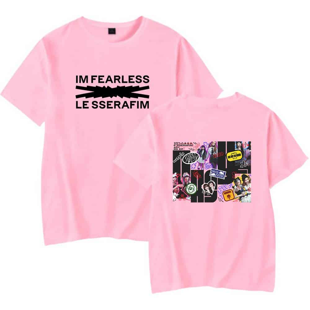 Pink T-shirt with bold black text "I'M FEARLESS" and "LE SSERAFIM" with a lightning bolt graphic; also features a collage of colorful images related to the K-pop group LE SSERAFIM.
